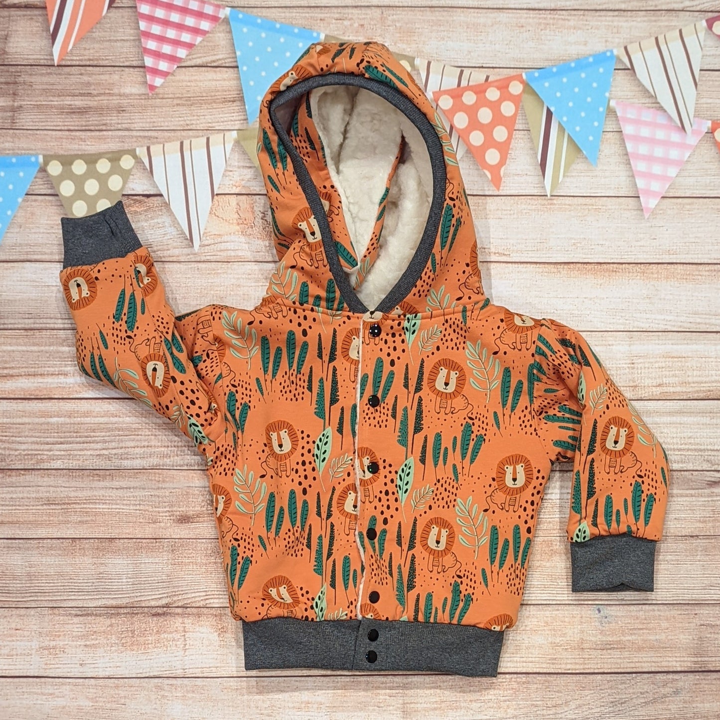 The gorgeous sherpa and orange lions reversible bunny hoodie. Handmade using sherpa fur, graphite ribbing and orange lions cotton French terry. Featuring front poppers and adorable bunny ears on the hood. Showing the reverse side.