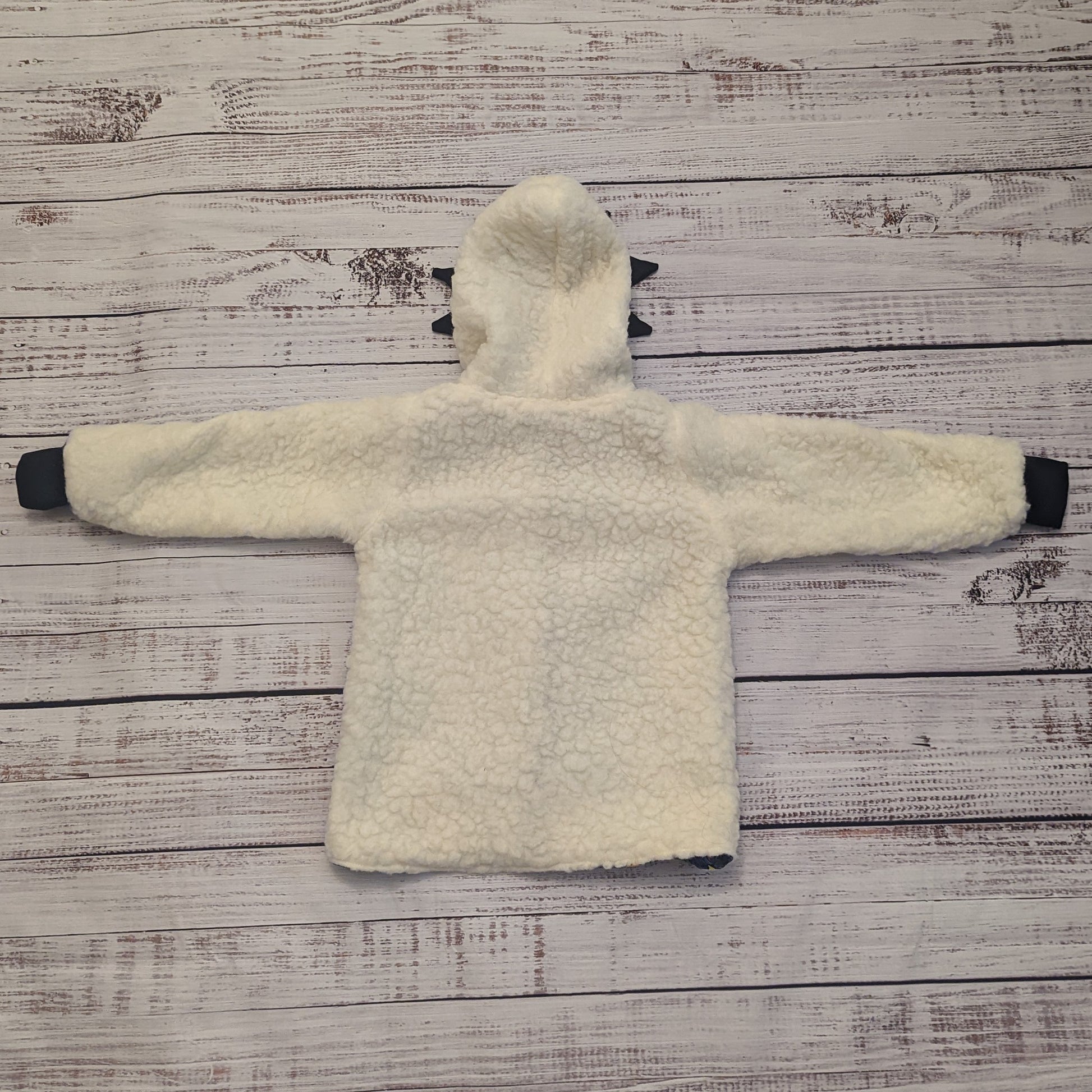 The ferociously cool street Dino reversible coat, shown with dinosaur teeth and spines for added fun. Handmade using street dino cotton French terry, black cotton ribbing and sherpa fur. Showing the back when used as a sherpa fur hoodie