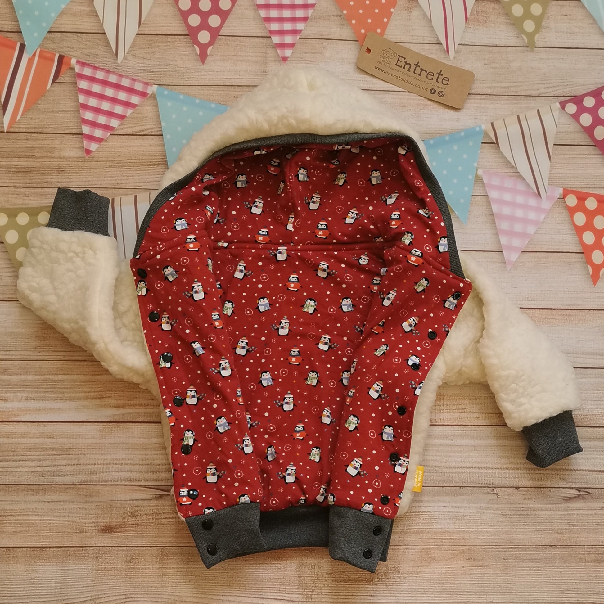 The festive and fun red christmas penguins hoodie, with warm sherpa fur. Shown open to reveal both sides.