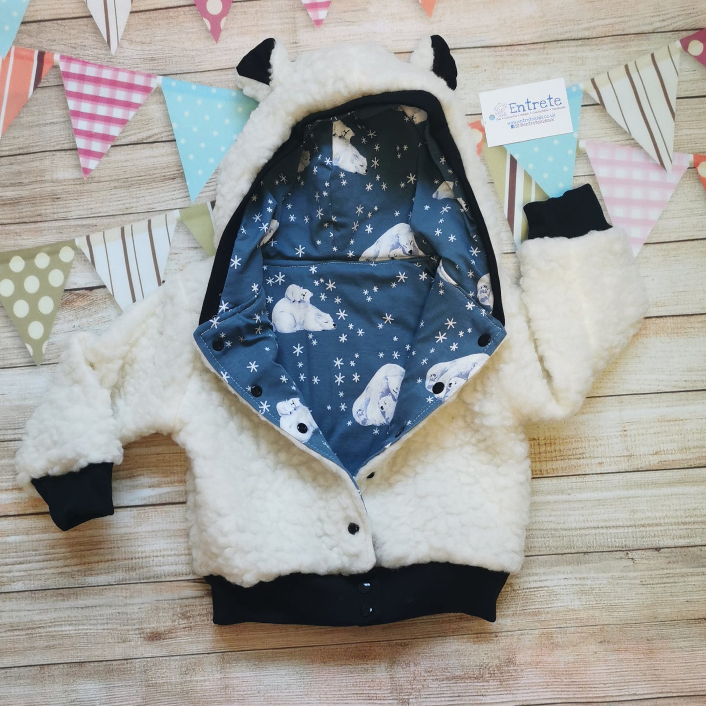 Polar bear hoodie shown with poppers open to reveal the gorgeous dusty blue polar bear cotton jersey reverse.
