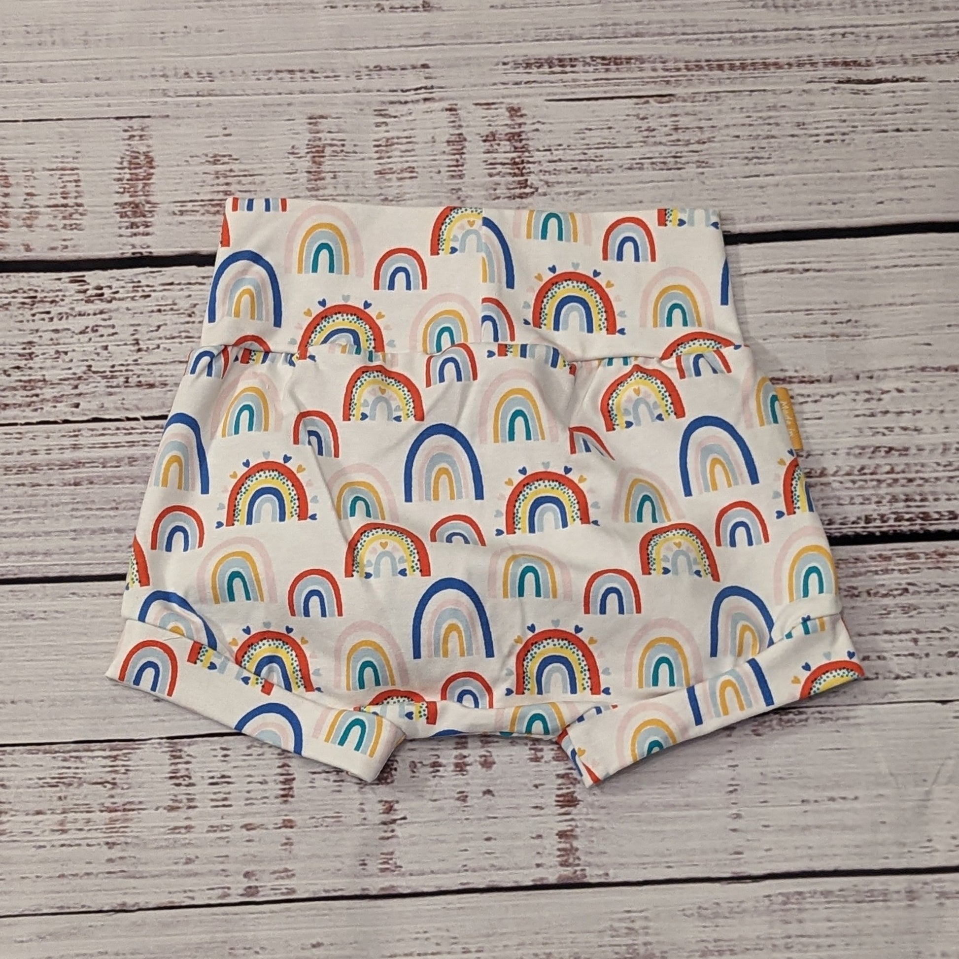 The fun colourful rainbows and hearts on white shorts. Handmade using white colourful rainbow hearts cotton jersey. Shown from the rear.