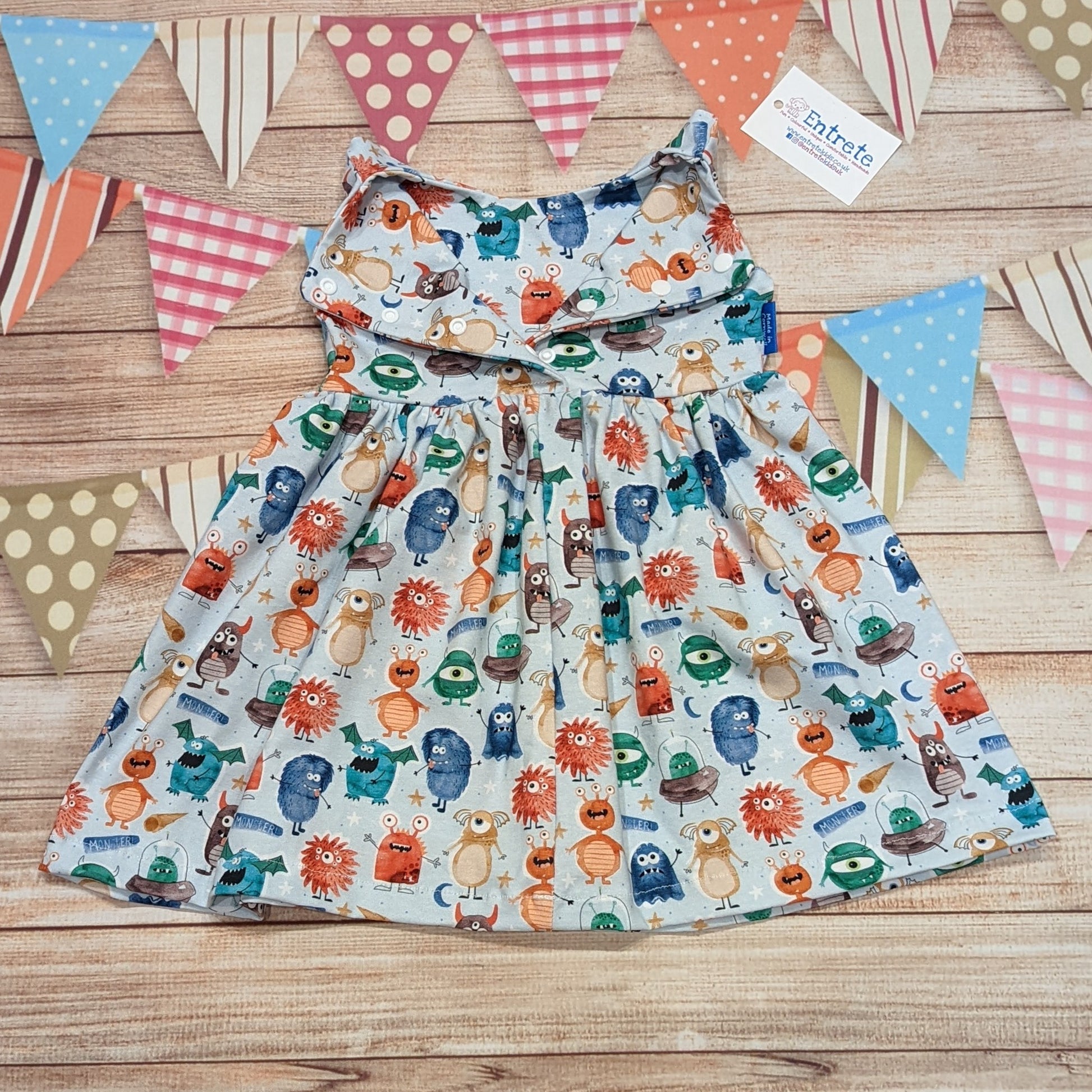 The ethical and fun girls monsters dress. Handmade using organic pale blue monsters cotton jersey. Showing the rear popper entry, which for sizzes below 9 months runs the length of the dress for easier changing.