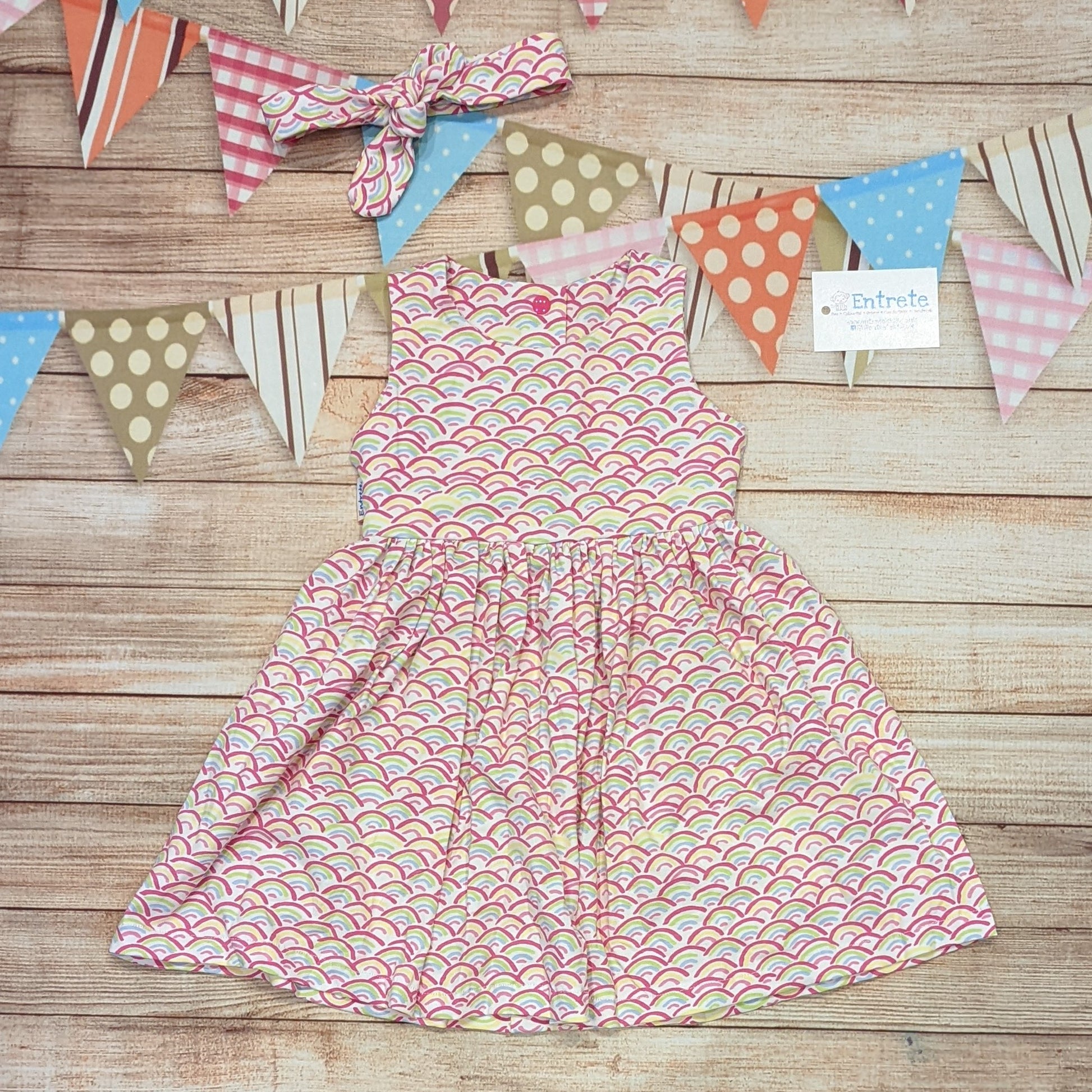 The adorable mini rainbows on white back popper dress. Shown with a matching headband (sold separately).