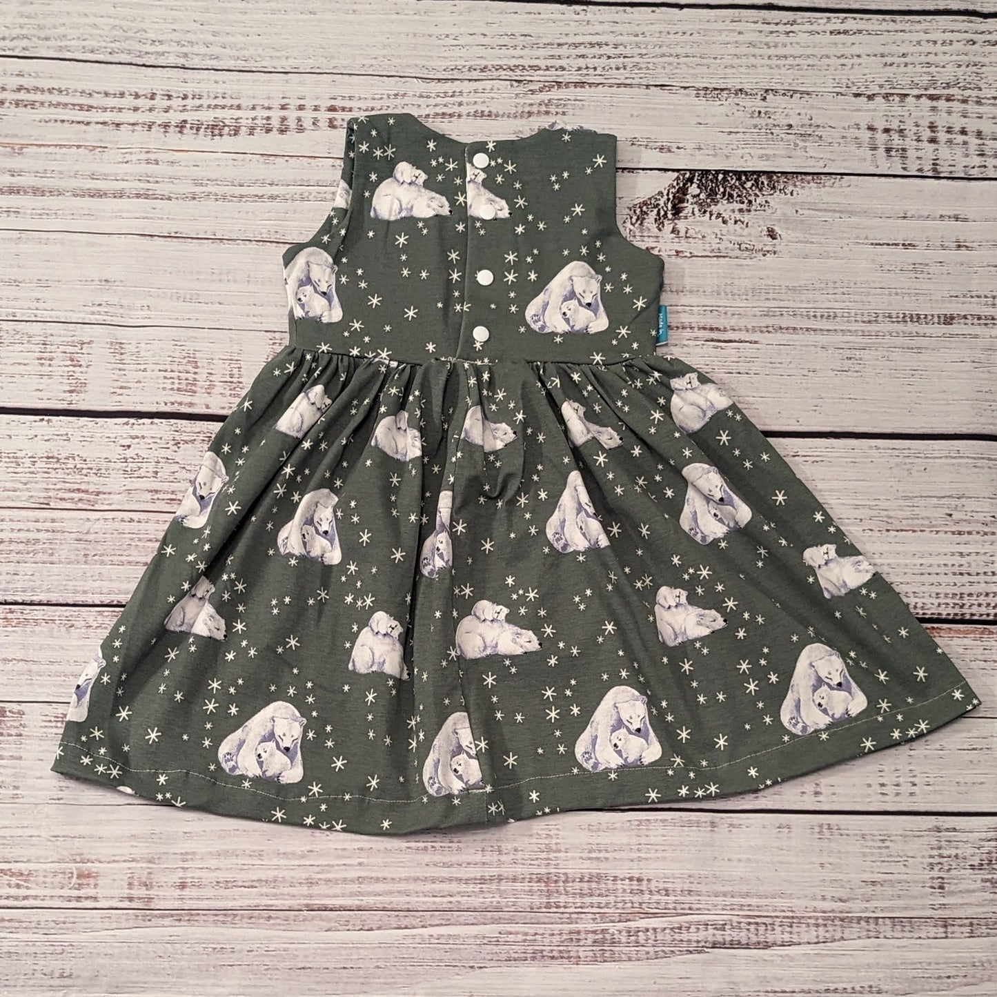 Rear of sleeveless girls Christmas dress, handmade using the gorgeous polar bears cotton jersey. With poppers used in dresses over 9-12 months, smaller sizes have poppers the length of the dress.