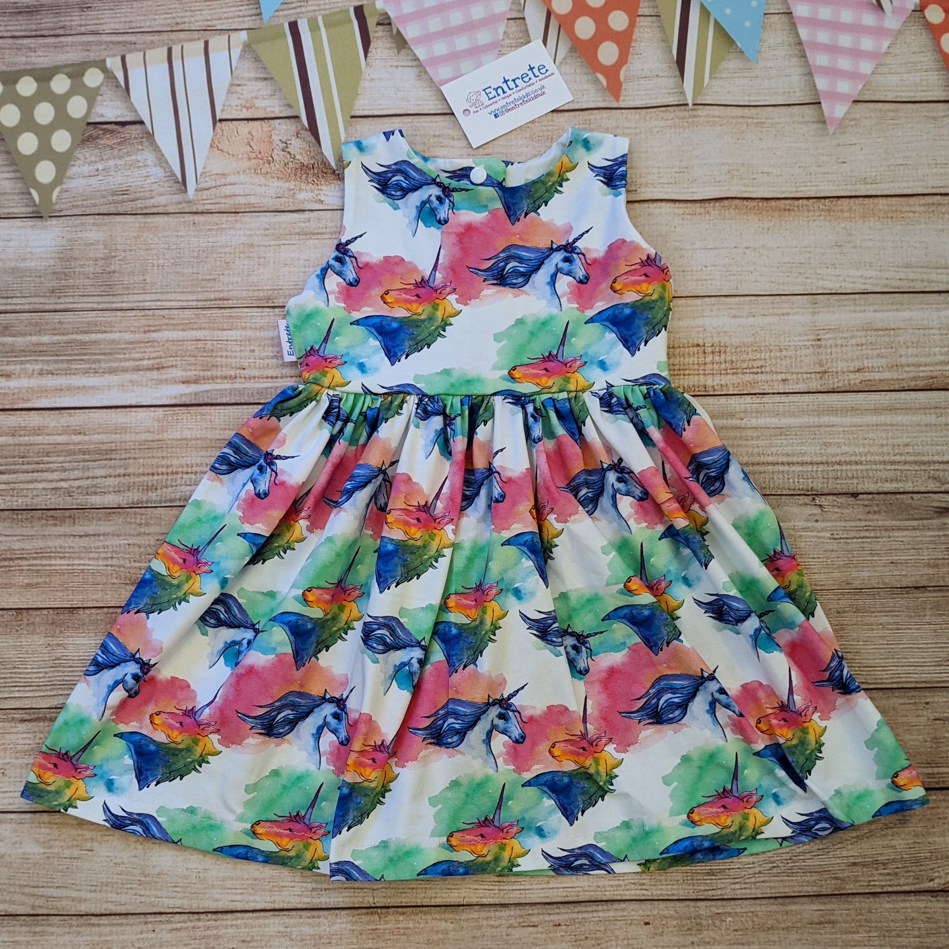 The gorgeously colourful unicorns on white sleeveless girls dress. Handmade using unicorns on white cotton jersey.