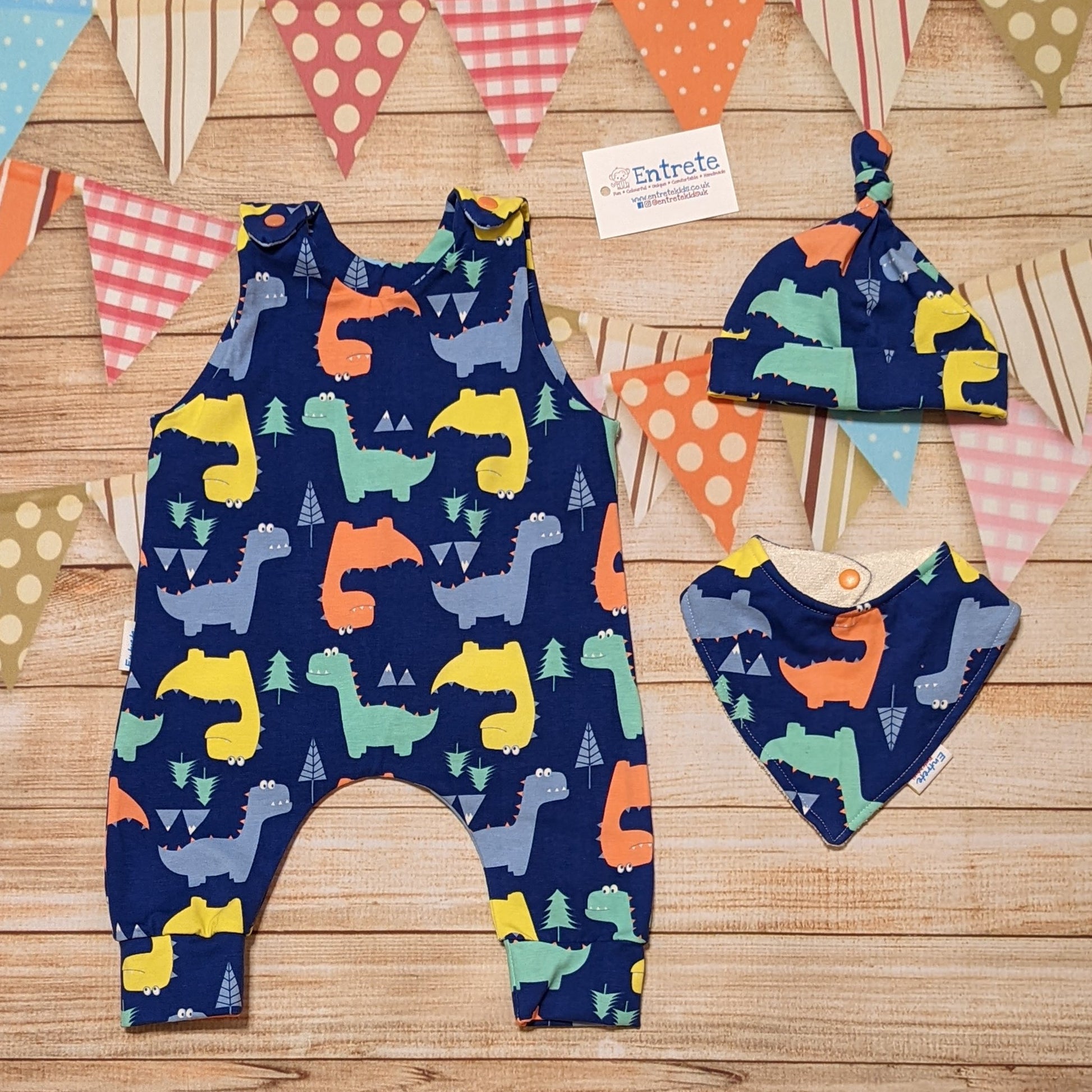 Colourful dinosaurs sleeveless romper, handmade using blue dinosaur cotton jersey. Shown with a matching bamboo bib and tie top hat (sold separately)
