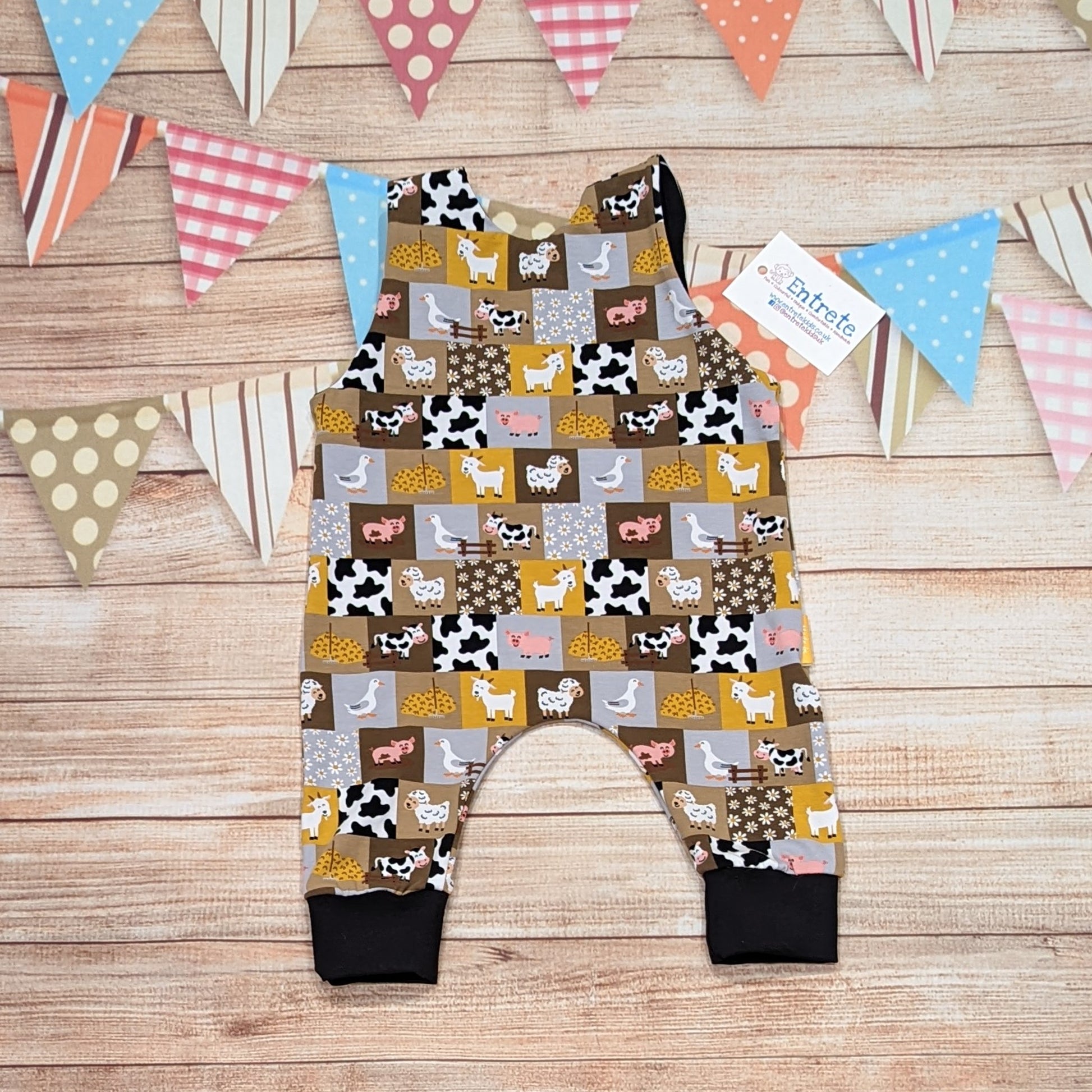 All the fun of the farmyard in this sleeveless romper. Handmade using checkboard farmyard and black cotton jerseys'. Shown from the rear.
