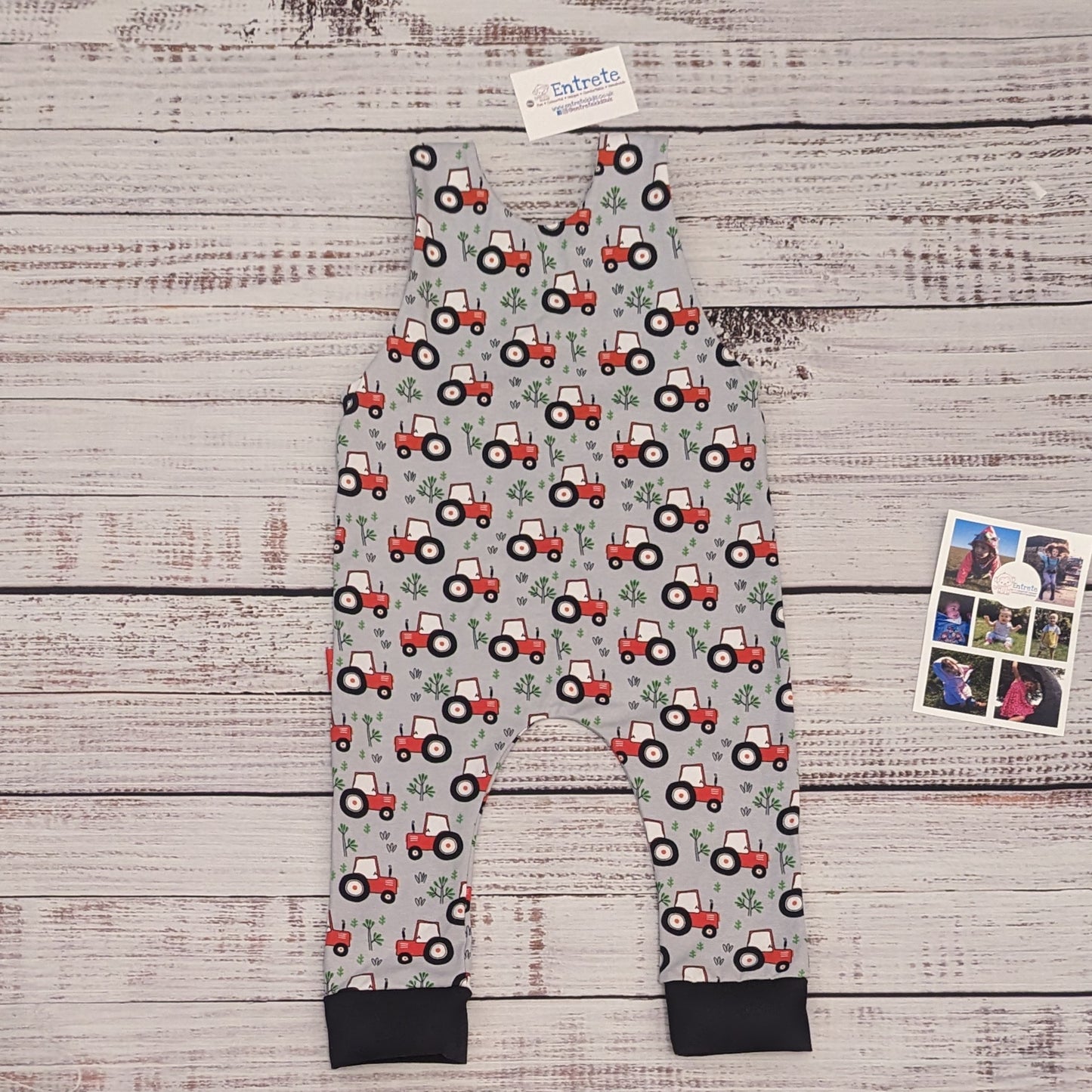 Fun red tractors on grey sleeveless romper. Handmade using grey tractors cotton jersey and black cotton ribbing. Shown from the rear.