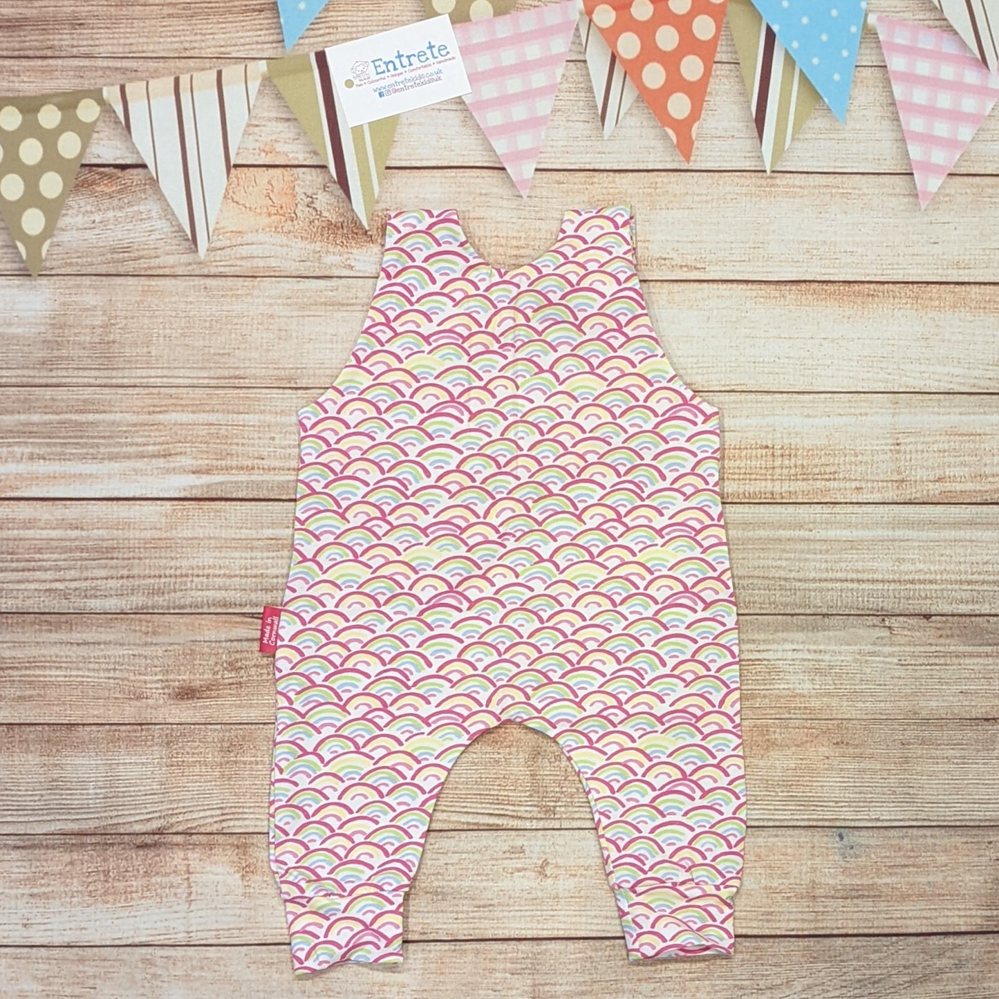 The adorable mini rainbows sleeveless romper. Handmade using mini rainbows on white cotton jersey. Shown from the rear.