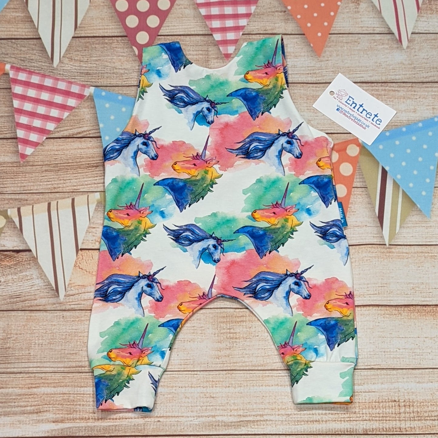 The gorgeous colourful unicorns sleeveless romper. Handmade using colourful unicorns on white cotton jersey. Shown from the rear.