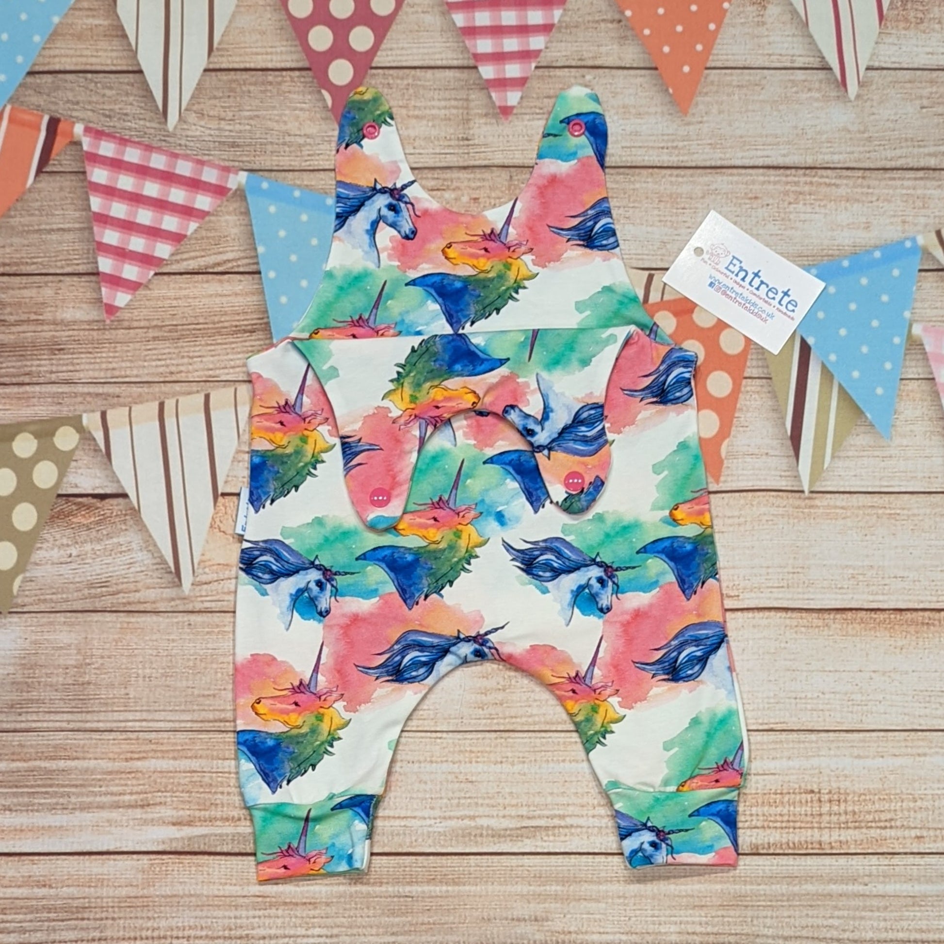 The gorgeous colourful unicorns sleeveless romper. Handmade using colourful unicorns on white cotton jersey. Shown with the shoulder popper entry open.