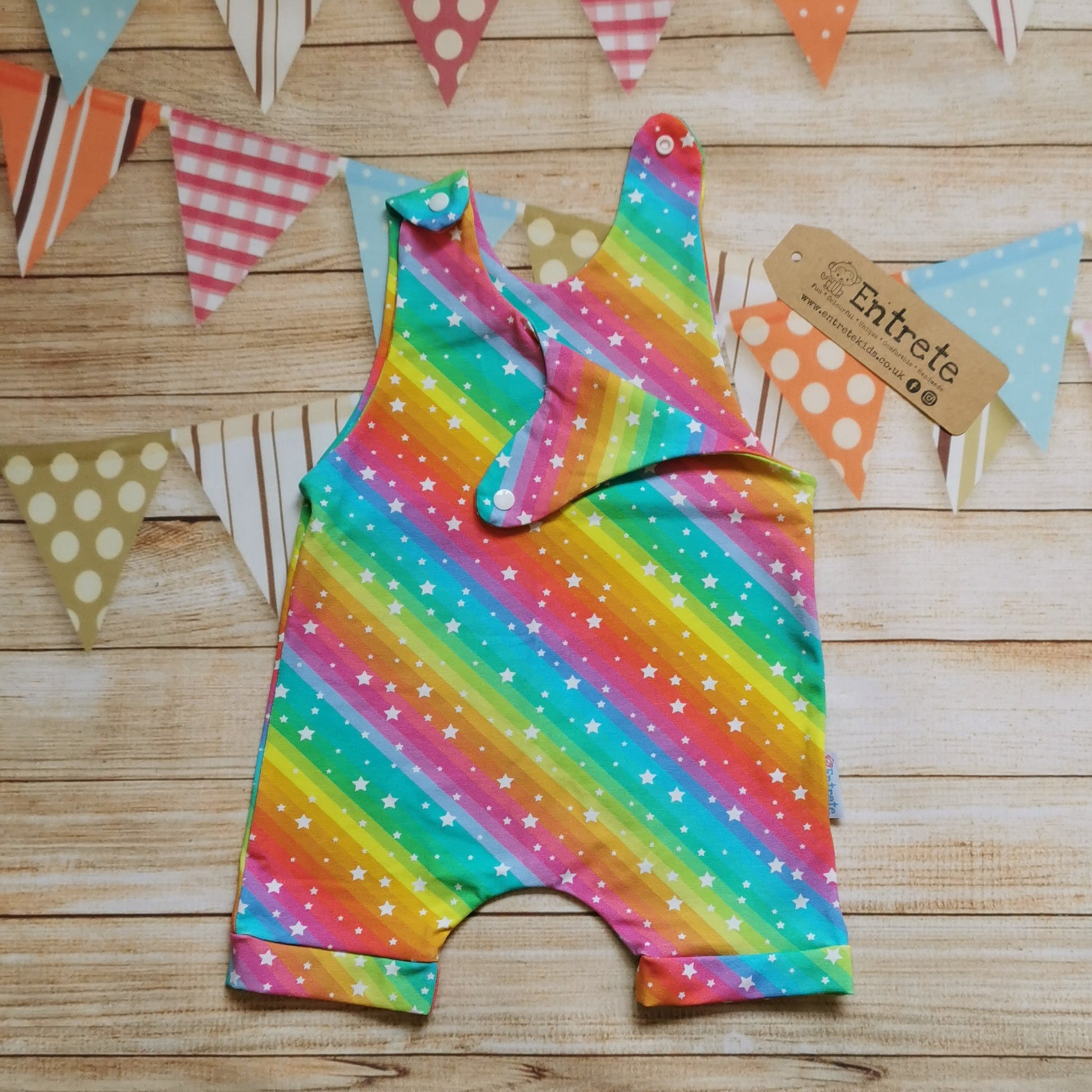 Girls & Babies romper shorts, handmade in the vivid and bright rainbow stars cotton jersey. Shown with one shoulder open.