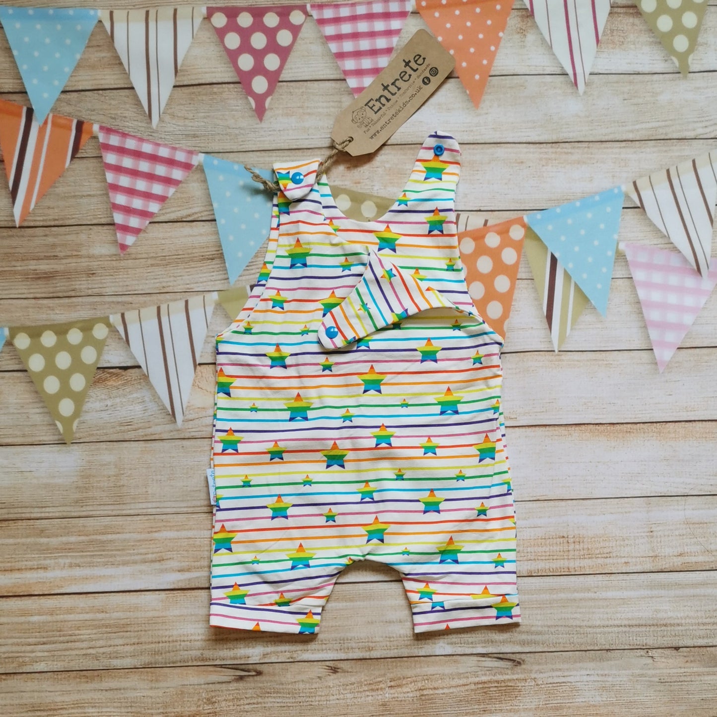 Unisex kids romper shorts, handmade using stunning rainbow stars cotton jersey. Shown with one of the shoulders open.