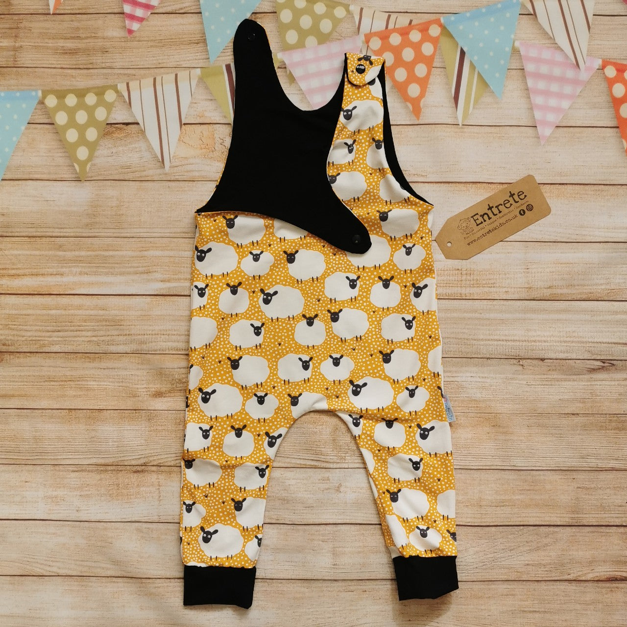The fun mustard sheep romper, perfect for your little lamb. Handmade using mustard sheep and black cotton jerseys'. Shown with one of the shoulder poppers open.
