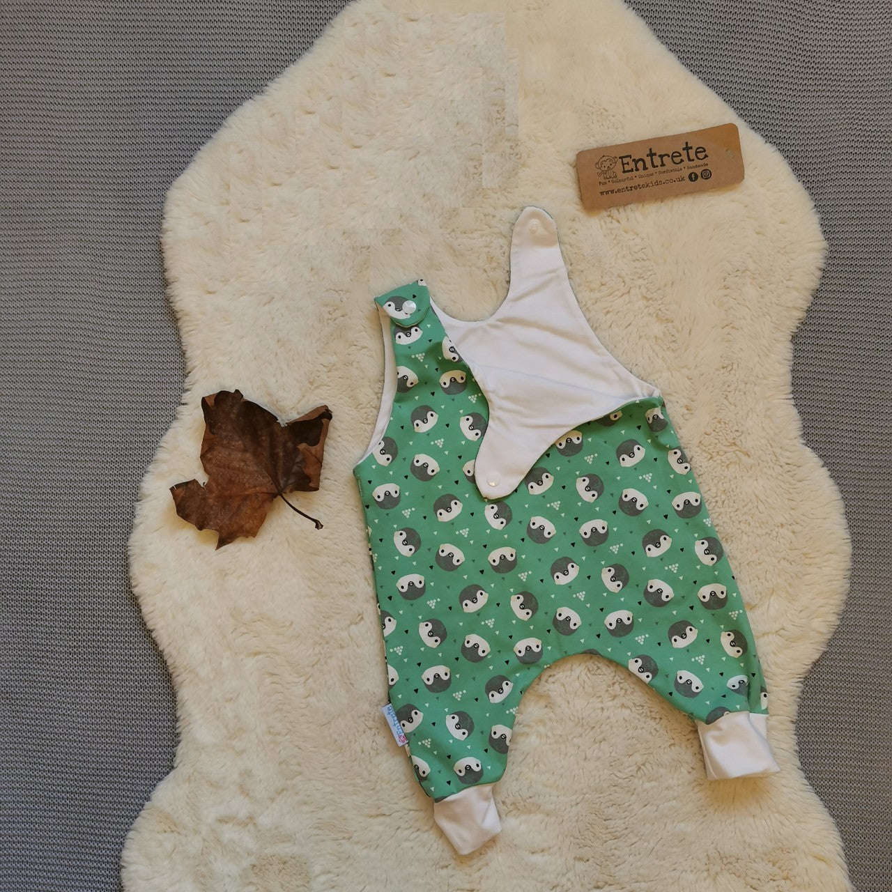 The gorgeously ethical organic mint penguins sleeveless romper. Handmade using mint penguins and white organic cotton jerseys' with a natural bamboo lining. Shown with one of the shoulder poppers open.