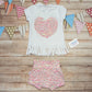The feminine and beautiful mini rainbows heart tassel tee. Shown as an outfit with mini rainbows on white shorts.