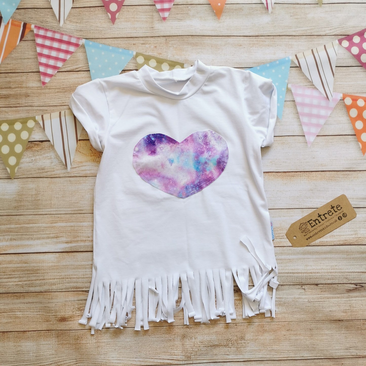 Girls tassel top, handmade using white cotton jersey and featuring a marbled galaxy cotton jersey heart. With  rolled sleeves and tassel finish.