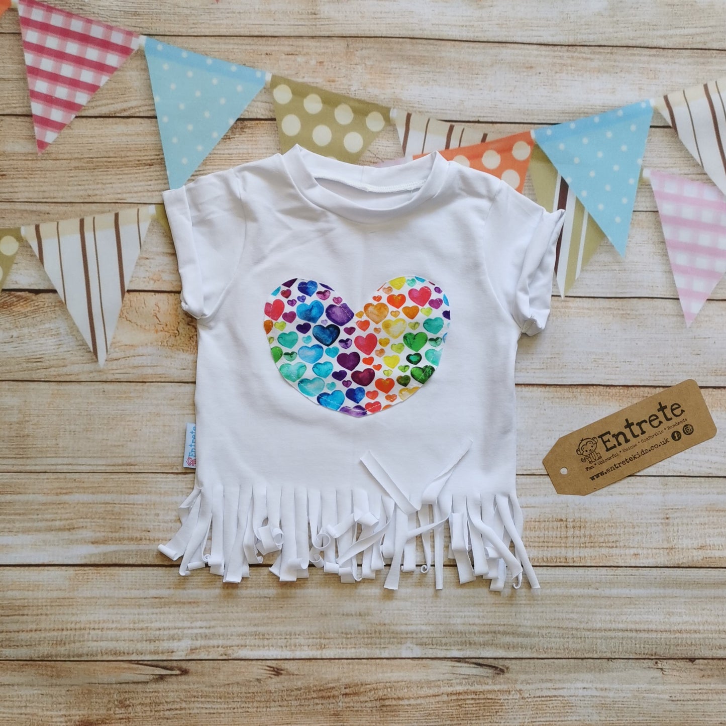 Gorgeous watercolour rainbow hearts heart tassel t-shirt. Lovingly handmade with rolled cuffs and tassels at the waist.
