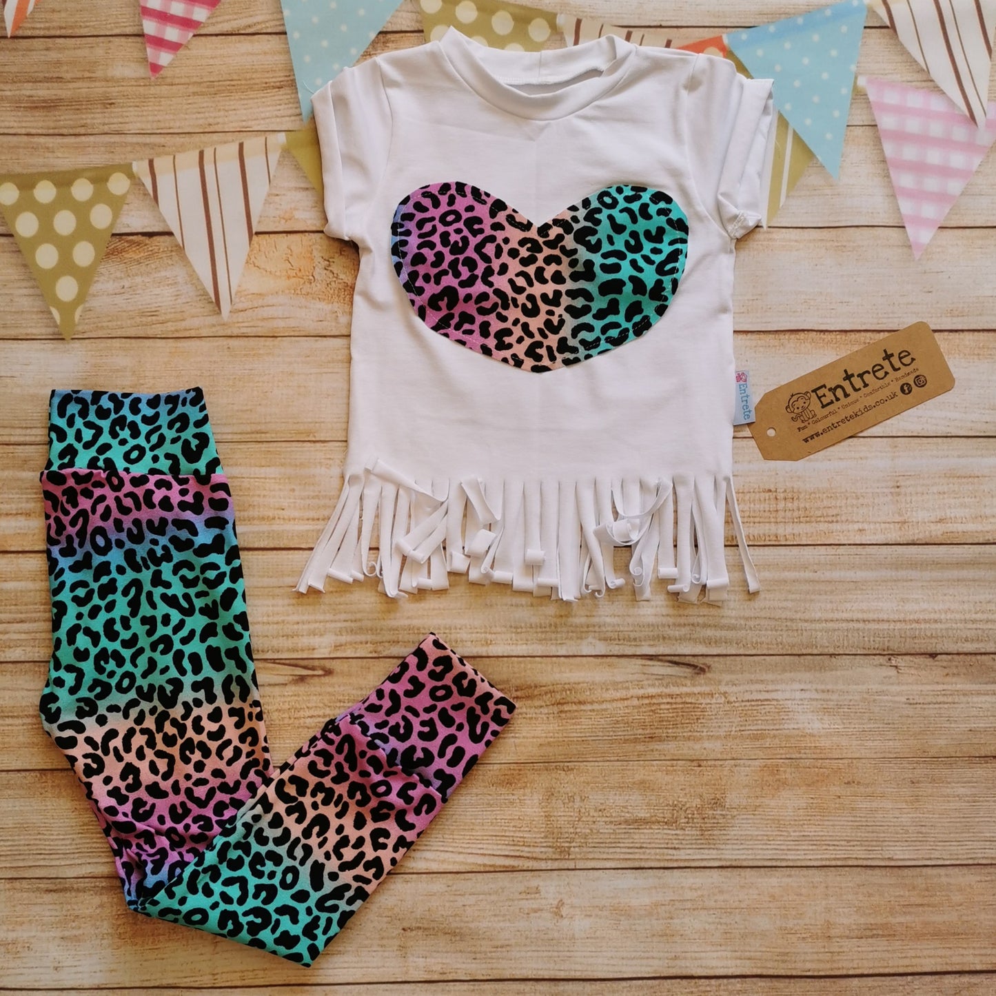 Girls rainbow leopard heart tassel tee shown as an outfit with rainbow leopard print leggings. (sold separately)