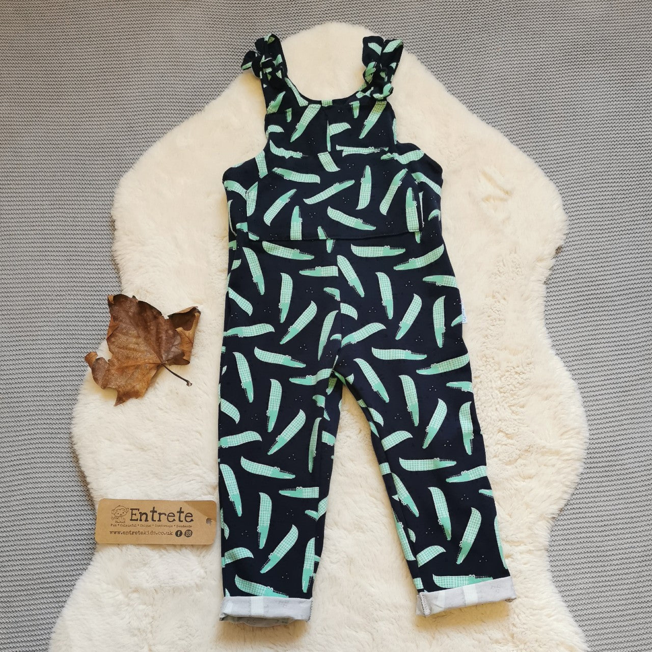 The amazingly fun navy crocodiles tie strap dungarees, handmade using navy crocodiles cotton jersey. Featuring a front pocket, rolled ankles and adjustable tie straps.