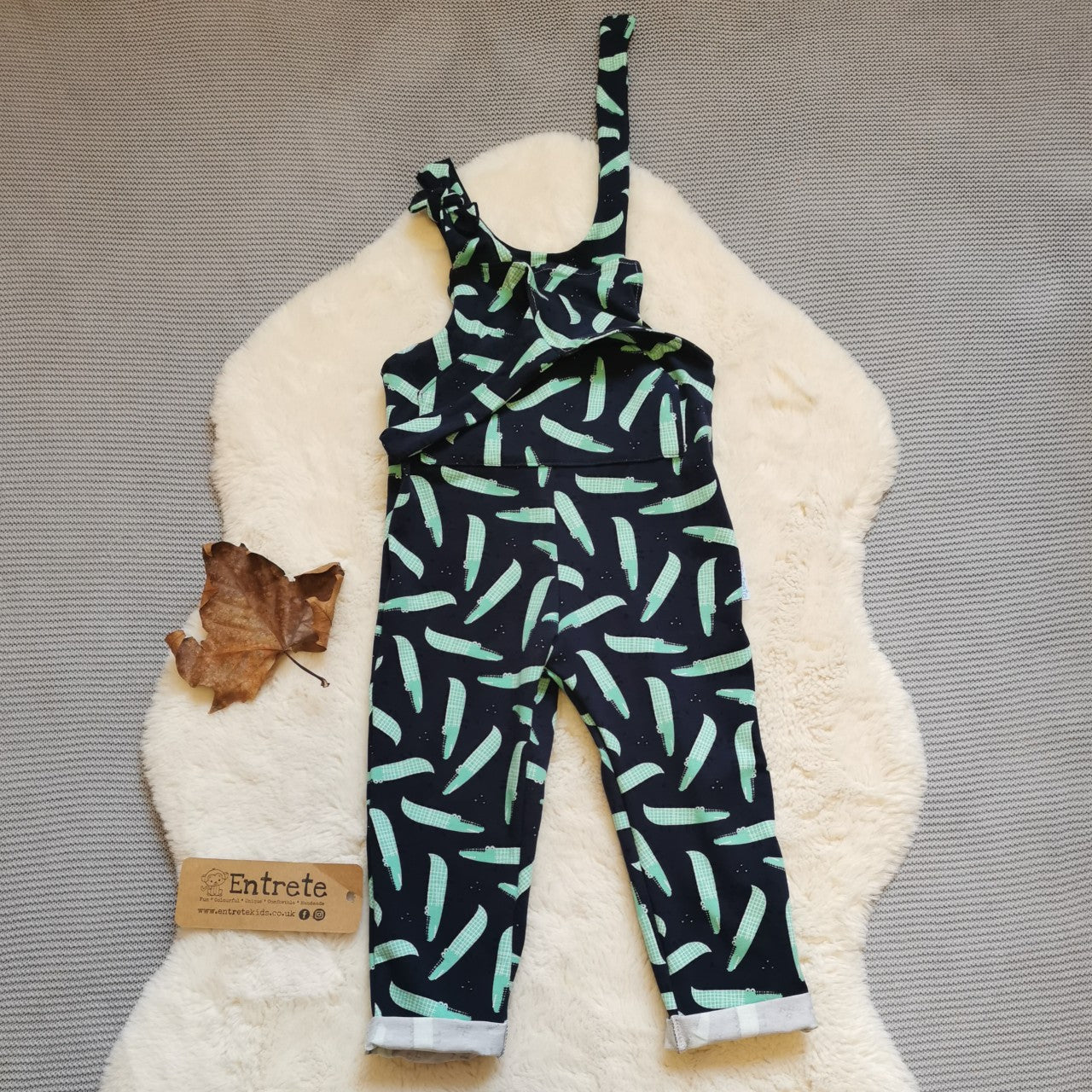 The amazingly fun navy crocodiles tie strap dungarees, handmade using navy crocodiles cotton jersey. Featuring a front pocket, rolled ankles and adjustable tie straps. Shown with one strap undone. 