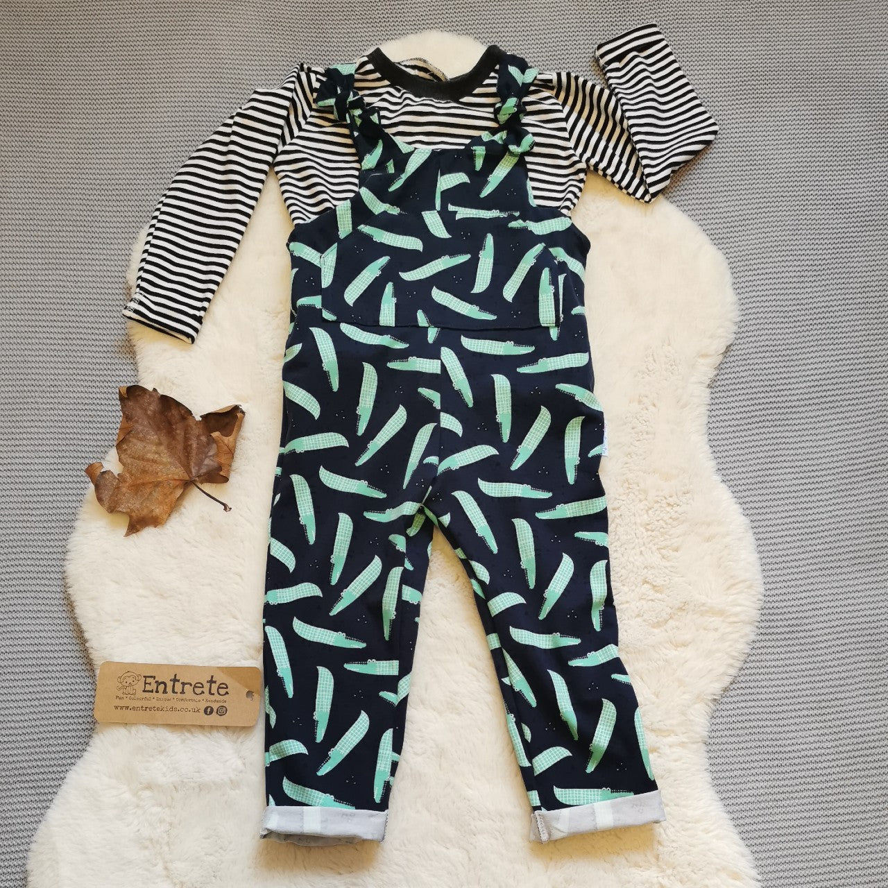 The amazingly fun navy crocodiles tie strap dungarees, shown with a monochrome striped top (sold separately).