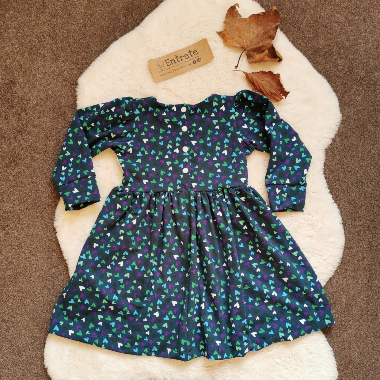 Girls & Babies back popper dress. Handmade in teal mini hearts cotton jersey. Rear view showing popper entry down to the waist available on sizes 9-12 months and above.