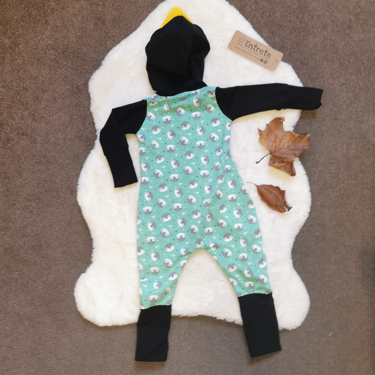 Rear of the ethical, fun and adorable penguin romper. Handmade using mint penguins, black and yellow organic cotton jerseys', with a natural bamboo hood lining. 