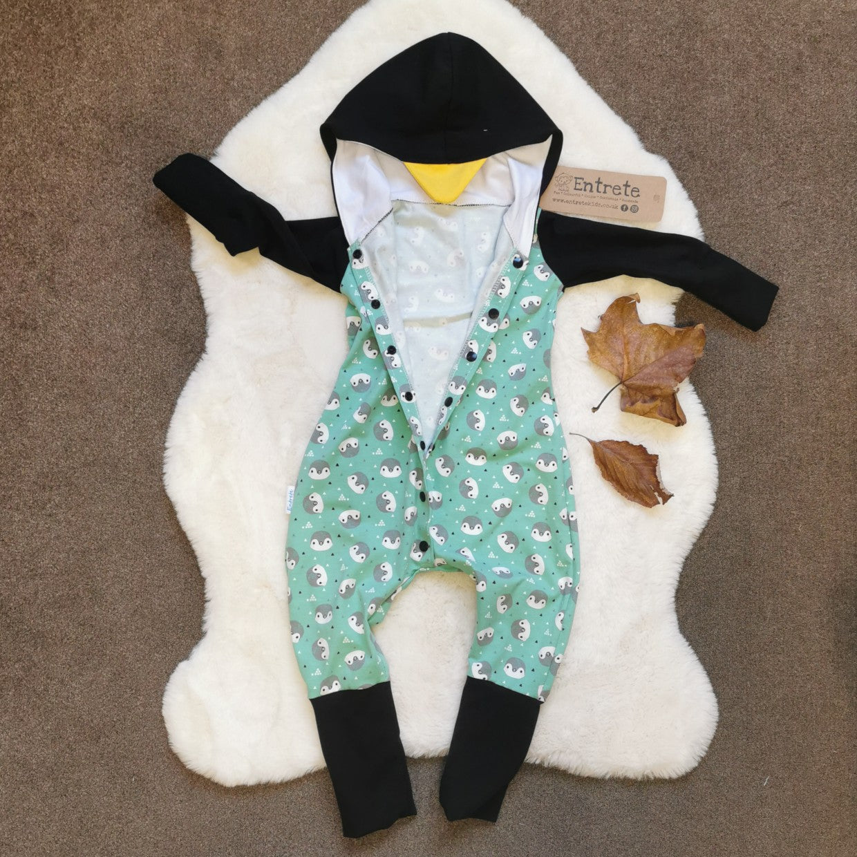 The ethical, fun and adorable penguin romper. Handmade using mint penguins, black and yellow organic cotton jerseys', with a natural bamboo hood lining.  Shown with front poppers open.