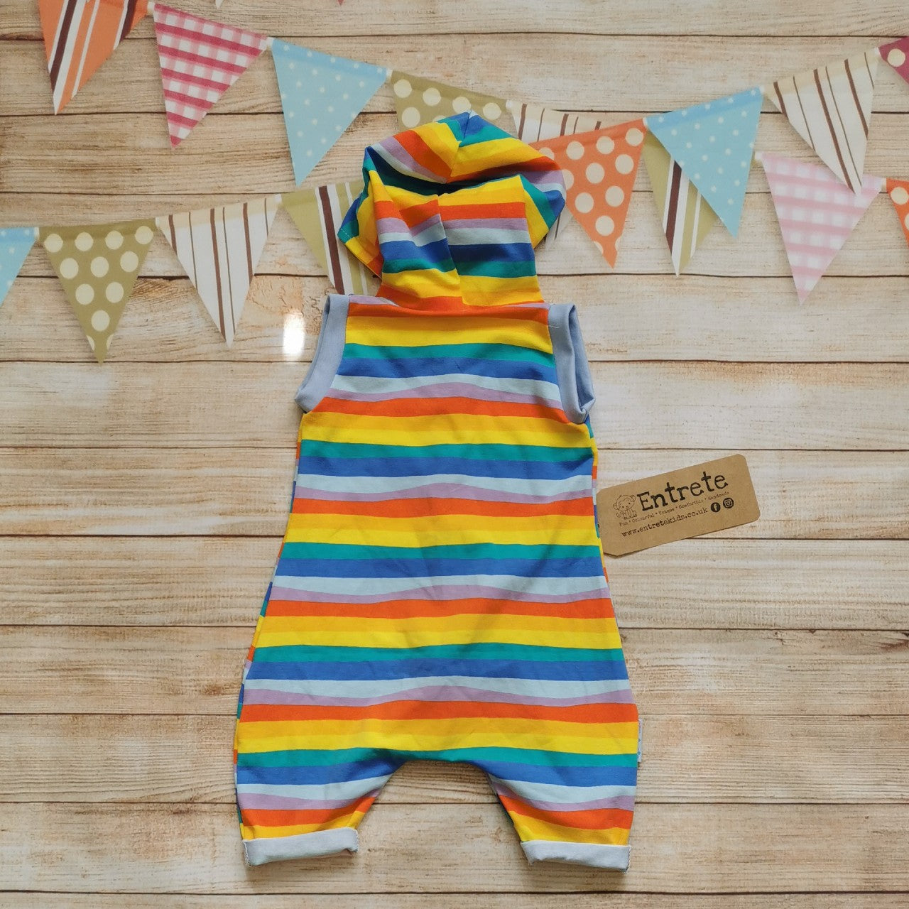 Back of Unisex Kids Hooded Bummie Romper, handmade in gorgeous red rainbow striped cotton jersey, with yellow organic cotton jersey hood lining and light blue cotton ribbing.