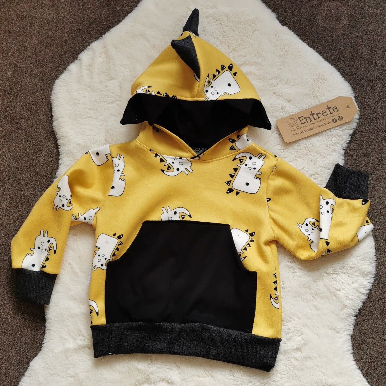 The adorable and fun mustard Dinosaur hoodie. With teeth and spines on the hood and a contrasting front pocket. Handmade using mustard dinosaurs cotton sweatshirt fleece, black cotton jersey and graphite cotton ribbing. With Closed Hood