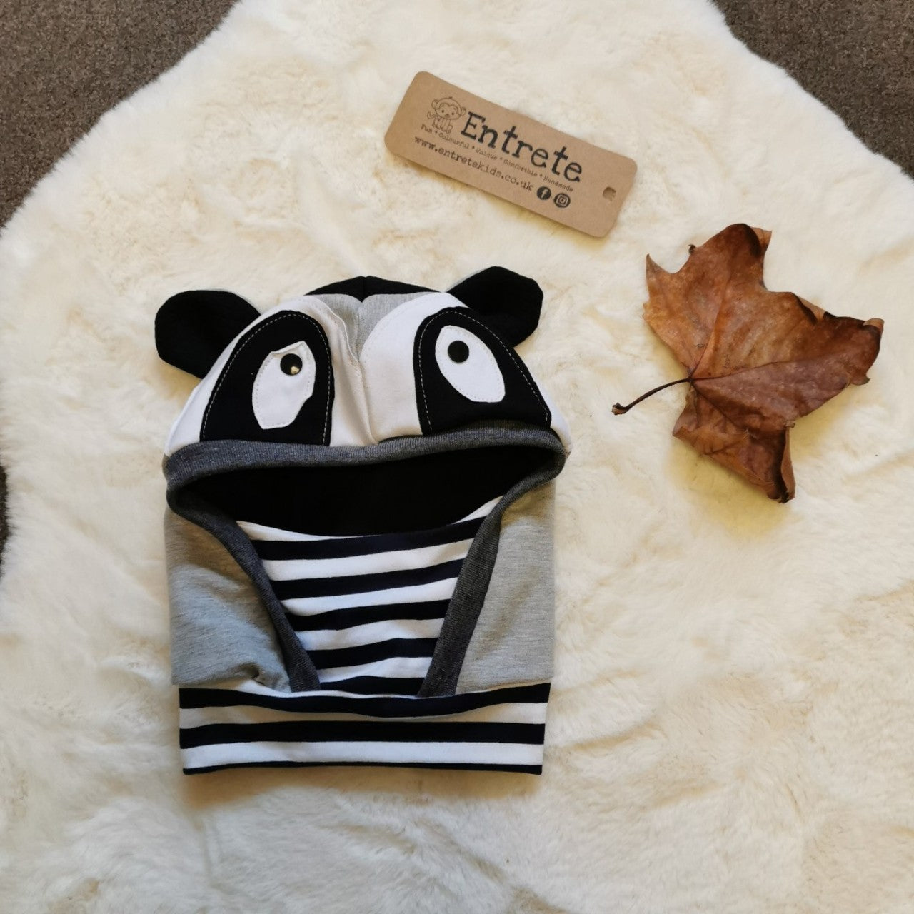 Front view of the playful and fun raccoon romper. Lovingly handmade from a mix of cotton jersey, cotton ribbing and cotton sweatshirt fleece.