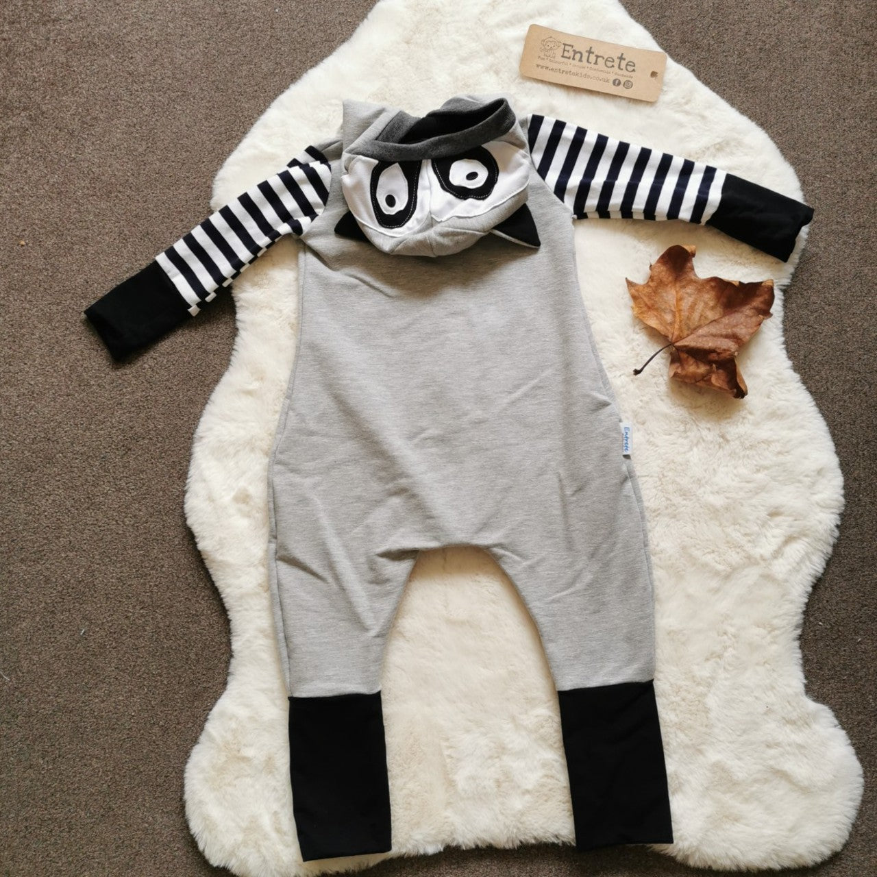 Rear view of The super fun Raccoon romper has lots of intricate detailing, your little one will love being a Raccoon! Handmade using grey cotton sweat fabric, monochrome striped, white and black cotton jerseys' and graphite cotton ribbing.